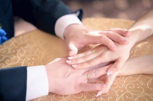 A married man and woman hold hands as they comfort each other