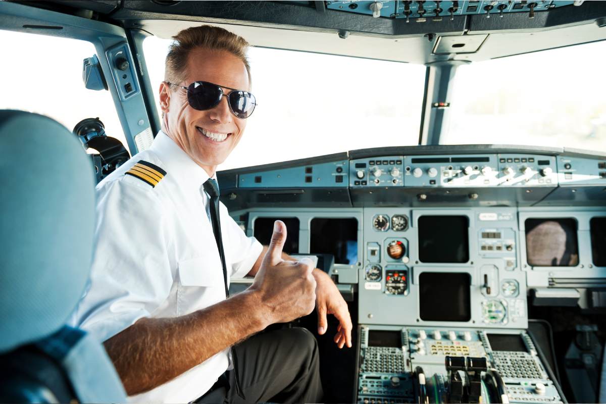 Smiling Pilot giving thumb up in cockpit